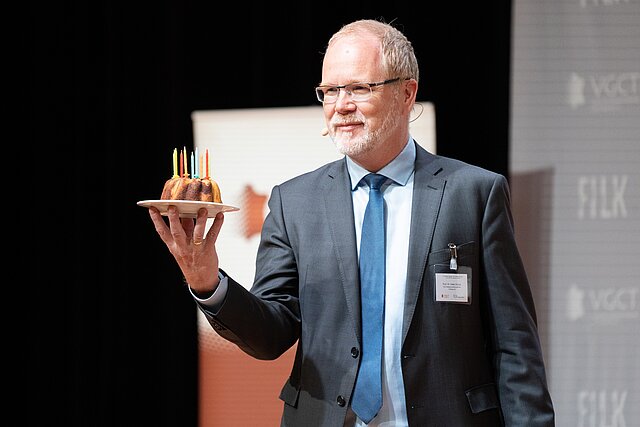 Prof. Dr. Haiko Schulz präsentiert den Geburtstagskuchen zum 10jährigen Jubiläum der Freiberger Ledertage